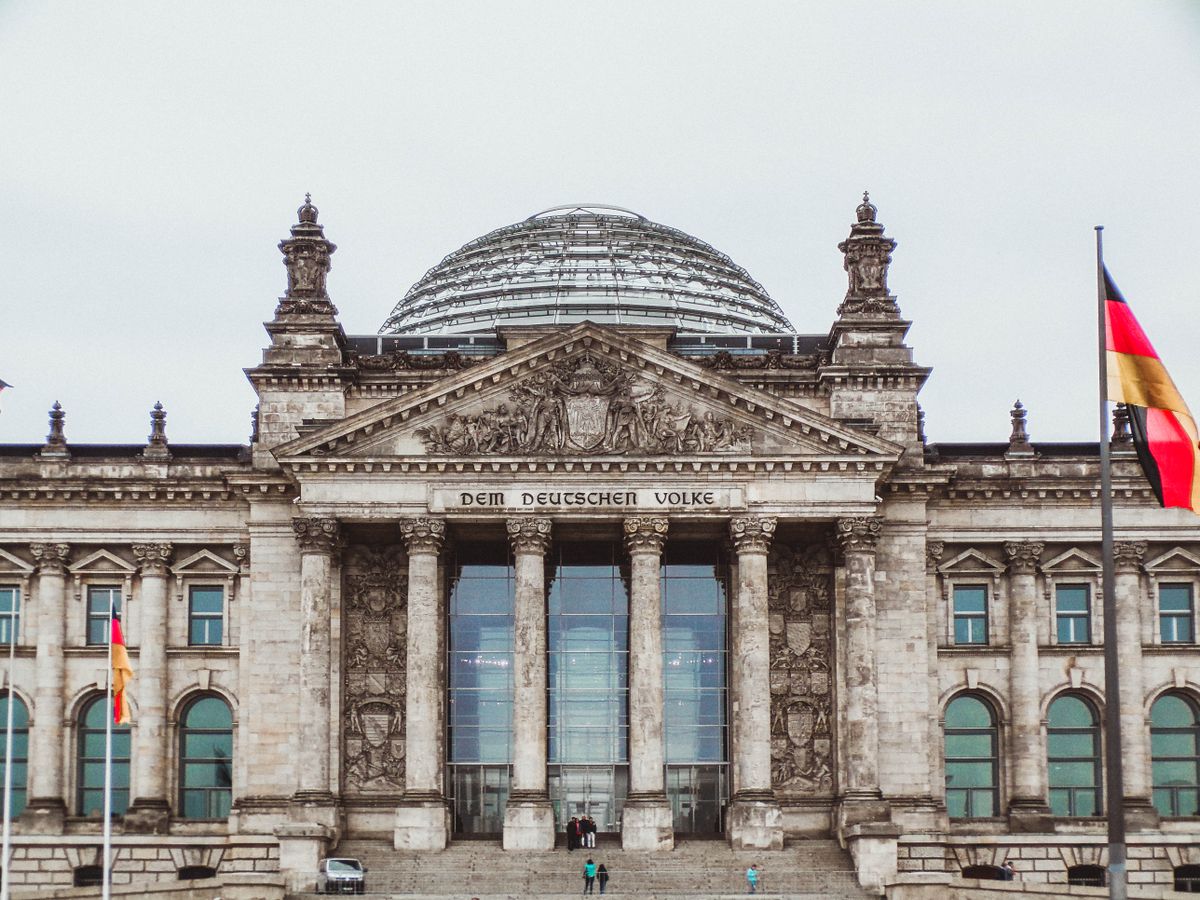 Reichstagsgebäude in Berlin mit Glaskuppel und Deutschlandfahne